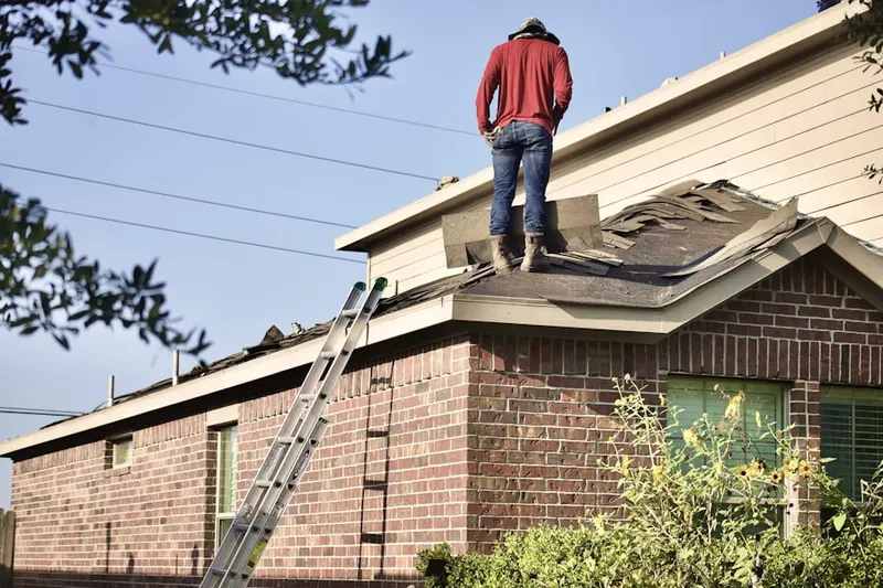 Professional roofer working on a residential roof in Carmerville